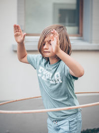 Cute girl playing while standing against wall