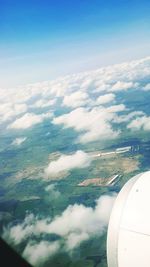 Aerial view of aircraft wing against cloudy sky