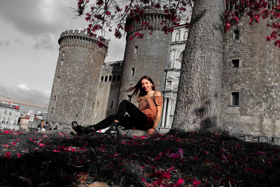 Woman sitting by building