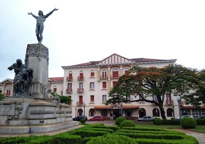 Statue in city against clear sky