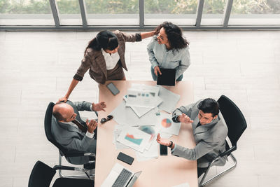 High angle view of business colleagues discussing at office