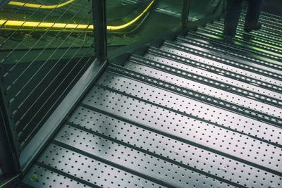 Low section of man moving down on metal steps