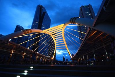 Low angle view of illuminated skyscraper against blue sky