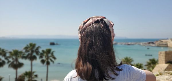 Rear view of woman looking at sea against sky
