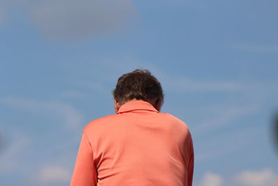 Rear view of man standing against sky