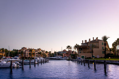 Houses by swimming pool against sky during sunset
