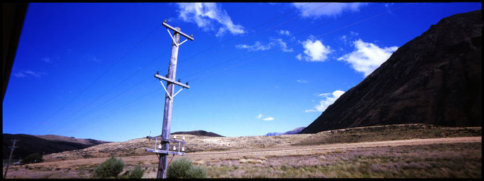 Wind turbines on mountain road against sky