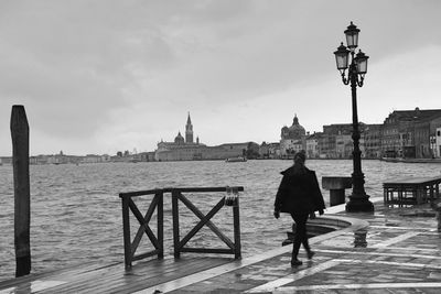 Man standing on bridge against sky