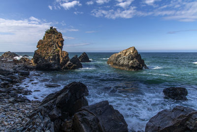Scenic view of rocks in sea against sky