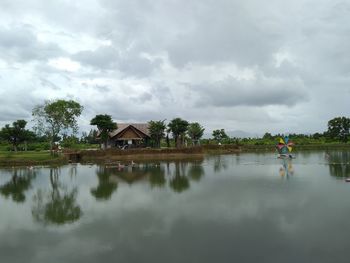 Scenic view of lake by building against sky