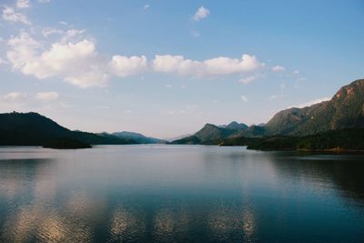 Scenic view of lake by mountains against sky