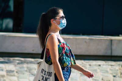 Side view of young woman looking away outdoors