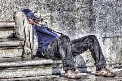 Close-up of people sitting on wall