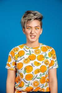 Portrait of a teenage boy against blue background