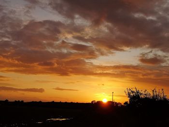 Scenic view of silhouette landscape against orange sky