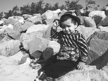 Portrait of cute girl sitting on rock