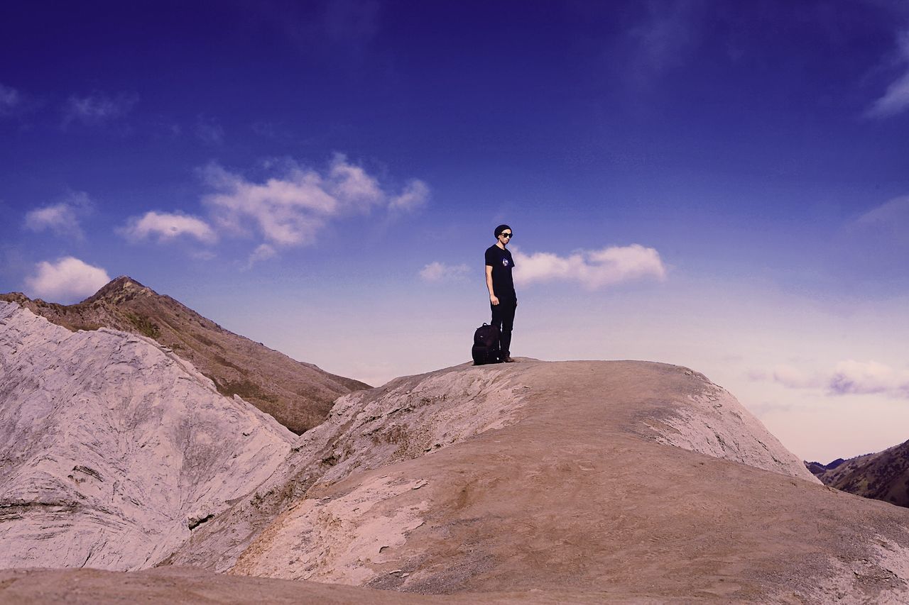 lifestyles, leisure activity, full length, sky, adventure, mountain, young adult, men, casual clothing, low angle view, young men, cloud - sky, mid-air, person, freedom, jumping, extreme sports, vacations