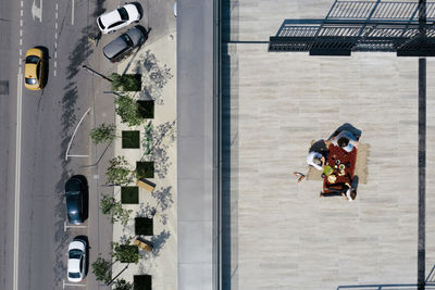 Aerial view of three people having a meal on the roof