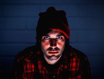 Portrait of young man against red wall