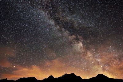 Low angle view of silhouette mountain against sky at night