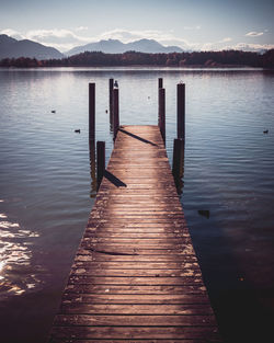 Wooden pier over lake against sky