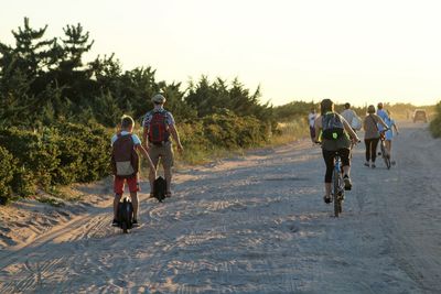 Rear view of people riding bicycle