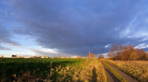 Scenic view of field against dramatic sky