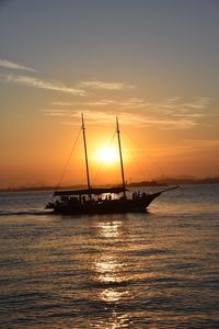 Sailboat in sea at sunset