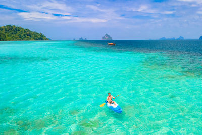 Man swimming in sea against sky