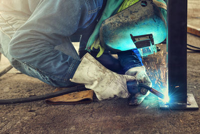 Low section of man working on metal