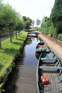 Boats moored in canal against sky