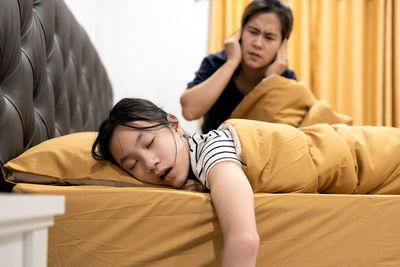 Full length of father and boy on bed