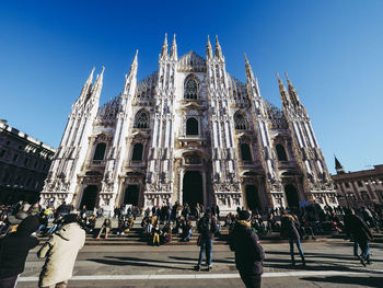 Group of people in front of cathedral against sky