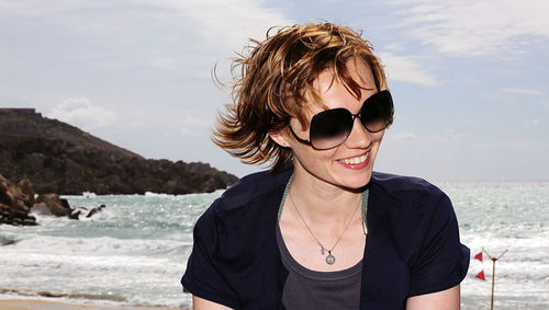 Portrait of woman wearing sunglasses at beach