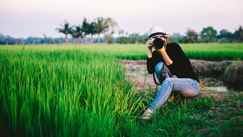 Man wearing sunglasses on field against sky