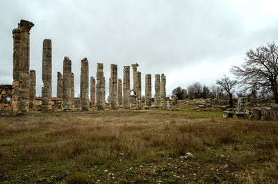 Abandoned ruins on field against sky