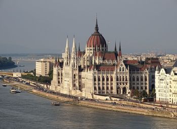 Danube river amidst buildings against sky in city of budapest