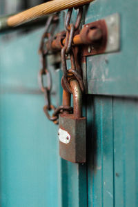 Close-up of rusty padlock hanging on closed door