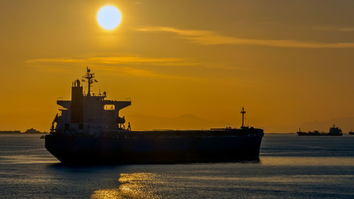 Silhouette ship sailing on sea against sky during sunset