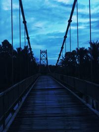 Footbridge against sky at dusk