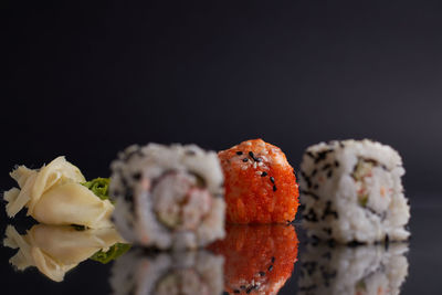 Close-up of sushi against black background