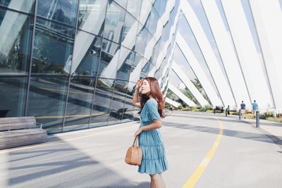 Woman standing on road in city