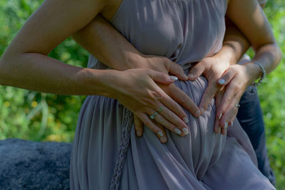Midsection of couple holding hands