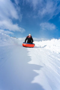 Women on snow covered landscape against sky