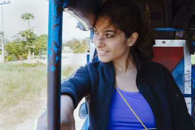 Smiling woman looking through window while traveling in vehicle