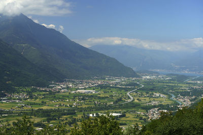 Aerial view of townscape by mountains against sky