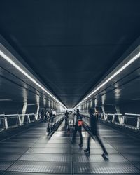 People walking on illuminated underground walkway