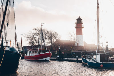 Sailboats moored on canal in city