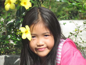 Close-up portrait of smiling girl with flowers