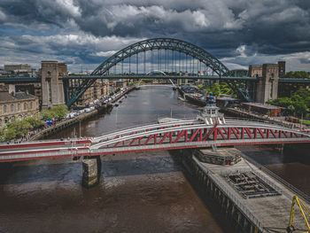 Bridge over river against cloudy sky